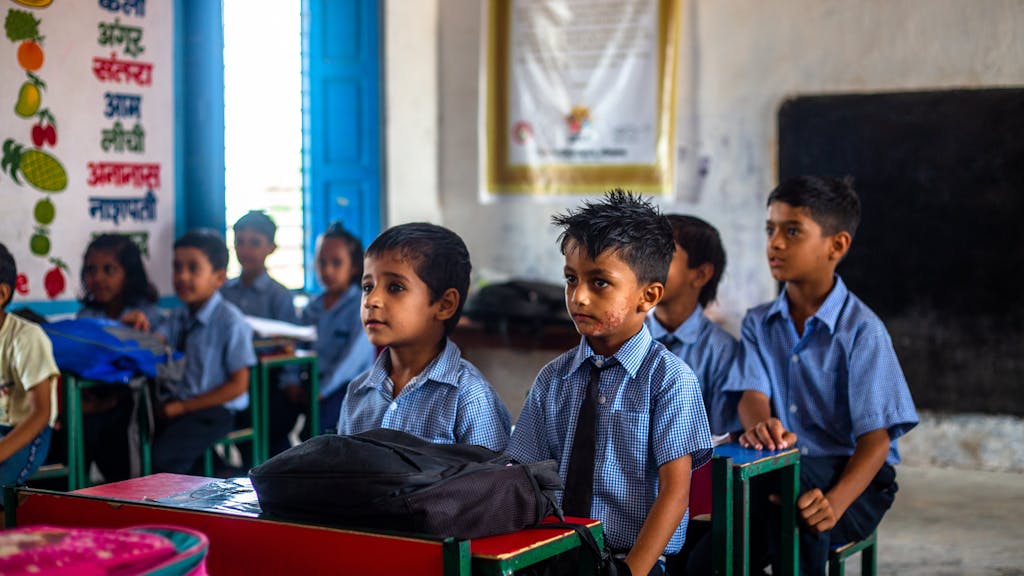Children sitting in a classroom with desks and chairs